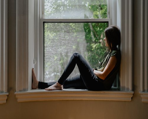 A person looking out of a window taking a break
